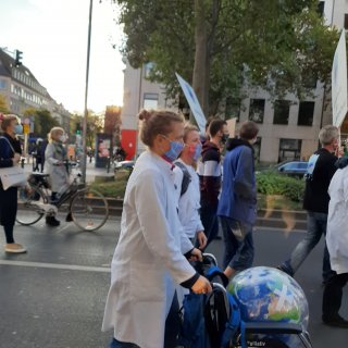 Frau schiebt Rollstuhl mit Weltkugel